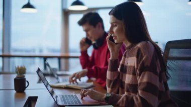 Çağrı merkezinde çalışan servis masası operatörleri dizüstü bilgisayarları yakından inceliyor. Modern ofisteki iki online yönetici siparişleri telefonla kabul ediyor. Genç meslektaşlar cep telefonu danışmanlarıyla konuşuyor..