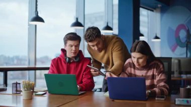 Takım lideri, ofisteki iki yöneticiyi yakın çekimde kontrol ediyor. Grup arkadaşları birlikte dizüstü bilgisayarlara bakma sorununu tartışıyorlar. Şirket çalışanları iş yerinde iş konusunda endişeliler