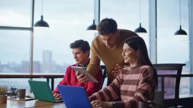 Takım menajeri, yaratıcı ajansların yakın plan bilgisayarlarında çalışan meslektaşlarını analiz ediyor. Gülümseyen iş arkadaşları başarılı takım çalışmalarından memnun kalarak tokalaşıyorlar. Stajyerlerin sonuçlarını kontrol etmekten mutluluk duyarım..