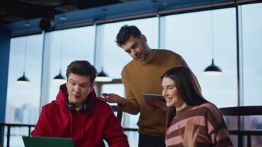 Ofis açılışı videoları yaratıcı ajans iş yerini kapatıyor. Arkadaş canlısı ekip sanal toplantıda dizüstü bilgisayarın web kamerasıyla konuşuyor. Gülümseyen meslektaşlar çalışma alanındaki online toplantıda projeyi tartıştılar.