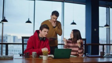 Yaratıcı ekip birlikte çalışma alanındaki dizüstü bilgisayarlara bakma projesinde beyin fırtınası yapıyor. Modern ofiste online girişimi tartışan üç iş arkadaşı. Genç profesyoneller iş stratejisi planlıyor.