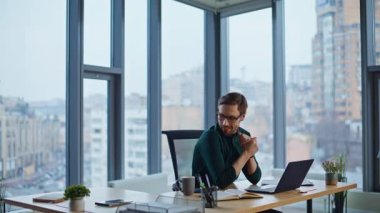 Lüks şirket ofisinde çay içen başarılı bir yönetici. Gülümseyen iş adamı kahvesini yudumluyor, ellerini ovuşturuyor ve başarıyı düşünüyor. Mutlu yönetici iş yerinde verimli bir işe ara verip dinleniyor..