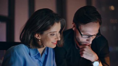 Başarılı ortaklar iş stratejilerini geceleri şirket işyerlerine yakın planlıyorlar. Gülümseyen takım arkadaşları yaratıcı projede birlikte çalışıyorlar. Dost canlısı ofis çalışanları dizüstü bilgisayarla açılışı tartıştılar.