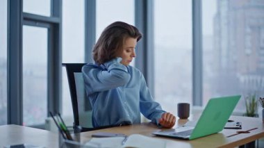 Motivasyonsuz çalışan boyun masajı yapıyor ofis panoramik penceresinden dizüstü bilgisayara bakıyor. Üzgün iş kadını, zor sorunları çözerken gerginlik hissediyor. Modern işyerinde profesyonel girişimci tükeniyor..