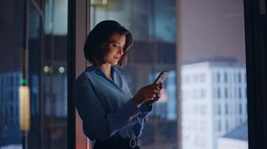 Geç saatte çalışan birinin cep telefonuna mesaj atması ofis penceresinin önünde duruyor. Güzel bir iş kadını gece işyerinde akıllı telefonlara mesaj atıyor. Gülümseyen girişimci cep telefonundan bankacılık bildirimi okuyor.