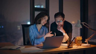 Ofisteki iş arkadaşları karanlık işyerindeki ışık altında fikirlerini paylaşıyorlar. Gülümseyen kadın yönetici gözlüklü sakallı adama iş projesini açıklıyor. Meslektaşlar pazarlama stratejisini tartışıyor.