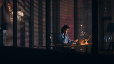 Gece ofisinden gülümseyen danışman arıyor. Mutlu iş kadını, iş yerinde fazla mesai yaparak akıllı telefonuyla pazarlık yapıyor. Neşeli yönetici gece geç saatlerde cep telefonuyla projeyi tartışıyor..