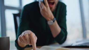 Öfkeli yönetici, modern ofiste cep telefonunu arayan defterini işaret ediyor. Duygusal patron, şirketin mali durumundan telefonla şikayetçi. Öfkeli işadamı kağıt fırlatıyor, akıllı telefon kavgası yapıyor..