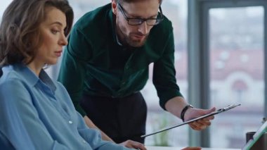 İşyerindeki kadın yöneticiye belgelerle mali verileri açıklayan yönetici. İki iş arkadaşı ofiste dizüstü bilgisayara bakmayı tartışıyor. Profesyonel ekip iş konularında birlikte beyin fırtınası yapıyor..