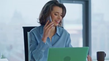 Mutlu finansör cep telefonunu arıyor. Lüks iş yerindeki belgelerle çalışıyor. Gülümseyen iş kadını cep telefonuyla harika mali raporları tartışıyor. Akıllı telefondan konuşan tatmin olmuş kadın CEO..