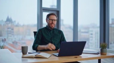 Sinirli CEO, iş belgelerini ofis masasında tutarken video konferansında tartışıyor. Öfkeli patron online toplantıda mali rapordan şikayet ediyor. Stresli iş adamı kavgası..