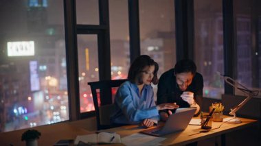 Profesyonel takım arkadaşları gece açık alanda dizüstü bilgisayar verilerini tartışıyor. Gülümseyen iş kadını, karanlık iş yerinde erkek müdürle konuşuyor. İnternetteki iki iş arkadaşı birlikte geç saatlere kadar çalışıyor..