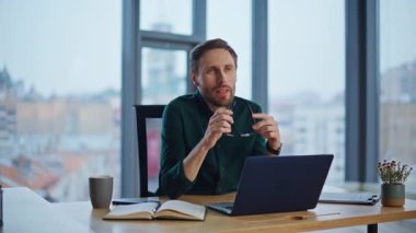 Modern iş yerindeki yetenekli koç videosu yakın çekim için arıyor. Profesyonel danışman dizüstü bilgisayarlı webcam oturma masasında el kol hareketi yapıyor. Çevrimiçi toplantıda kendine güveni tam bir iş adamı.