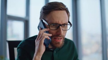 Ofiste akıllı telefondan bağıran çılgın iş adamı. Cep telefonuyla bağıran kızgın yönetici stresli sohbeti duygusal olarak bitiriyor. Gergin CEO 'nun gözlüğünü çıkarması hayal kırıklığı yaratıyor..