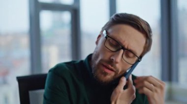 İş yerindeki iş meselelerini açıklayan profesyonel hoşnutsuz cep telefonu araması. Stresli iş adamı elinde kağıtlarla akıllı telefonlardan bahsediyor. Endişeli yönetici telefonda şikayet ediyor..