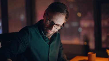 Kapanış neşeli girişimci gece ofisinden arıyor. Gülümseyen işadamı karanlık şirket işyerinde cep telefonuna cevap veriyor. Sakallı yönetici arkadaşça bir telefon görüşmesi yapmaya başladı..