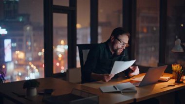 Deli işadamı cep telefonu diye bağırıyor ve gece ofisinde mali raporları tutuyor. Öfkeli yönetici akıllı telefon görüşmesinde iş belgelerinden şikayet ediyor. Sinirli girişimci stresli cep telefonu konuşmasını bitirdi.