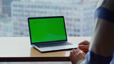 Şehir merkezindeki ofisteki bilgisayarın dokunmatik dokunmatik parmak izi. Bilinmeyen serbest çalışan panoramik odadaki yeşil ekranlı laptoptan e-posta gönderiyor. Kromakey ağ kitabıyla oturan tanınmayan bir adam.