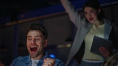 Gecenin kazananı dizüstü bilgisayara bakıyor. Meslektaşlarının portresiyle sevinç dolu bir başarı. Yenilikçi bir başlangıç takımı duygularını paylaşıyor ve beş yakın çekim yapıyor. Tasarım stüdyosundaki büyük başarıyı kutlayan heyecanlı iş arkadaşları