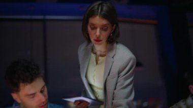 Kadın uzman, akşam iş yerinde stajyerlere yardım ediyor. Kurumsal akıl hocası acemi eğitmenlere ofiste talimat veriyor. Öğretmen eğitmeni yeni bilgileri açıklayan genç işçileri eğitiyor