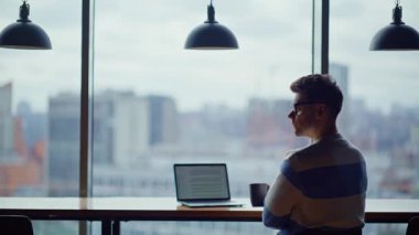 Şehir manzaralı ofiste çay içen rahat programcı. Odaklanmış iş adamı espresso molasının tadını çıkarıyor. Yönetici girişimci panoramik pencere iş yerinde kahvesini yudumluyor