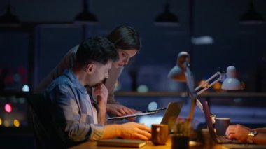 Kadın asistan gece açık mekan kapanış belgeleri gösteren geliştiriciye yardım ediyor. Geç kalmış şirket arkadaşları birlikte proje planlamayı tartışıyorlar. Şirket danışmanı karanlık akşam işyerinde stajyerlerle konuşuyor. 