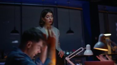 Gergin iş arkadaşları proje sorununu tartışıyorlar. Şirket danışmanı kadın yöneticilerin evrak dosyalarını tutmasına yardım ediyor. Endişeli ekip gece ofisinde çalışıyor. Konuşan kadın stajyerler.