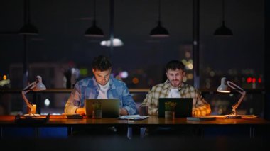 Karanlık ofiste dizüstü bilgisayarda çalışan profesyoneller el sıkışıyor. Masada oturan ciddi bir adam meslektaşıyla fikir alışverişinde bulunuyor. Şehir akşam iş yerinde bilgisayar kullanan iki geliştirici fikir alışverişinde bulundu