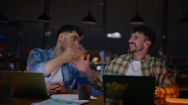 Ofis çalışanları tokalaşma akşamını kapatıyor. Başarılı girişimcilerin birlikte konuşması karanlık iç mekanlarda ortak bir karara varır. Sanat yönetmeni ve grafik tasarımcısı pazarlama kampanyasını tartışıyor