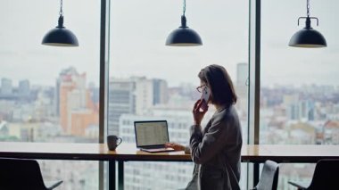 Başarılı yönetici, panoramik pencere kapanışında ortaklarla telefon görüşmesi yapıyor. Resmi takım elbiseli iş kadını cep telefonuyla iş anlaşması yapıyor. Meşgul avukat tezgahta oturuyor.