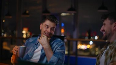 Ofisteki elemanlar akşam şehir merkezinde eğleniyorlar. Mutlu meslektaşlar çay içerken yaratıcı, karanlık bir yerde iletişim kuruyor. Molada konuşan pozitif serbest çalışanlar. İki adam birlikte dinleniyor. 