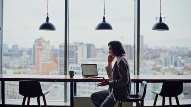 Öfkeli yönetici, ofisteki panoramik pencerede duygusal olarak oturarak telefonu arıyor. Kızgın patronun telefonda bağırması tatminsiz iş sonuçlarını yakınlaştırıyor. Kadın yönetmen sohbeti bitiriyor umutsuzluk hissediyorum 
