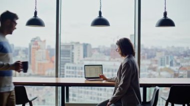 Adam panoramik pencerelere iş arkadaşını getiriyor. Şehir merkezindeki resmi olmayan bir ortamda iş adamları konuşuyor. Kaygısız çift iş yerinde flört ediyor. Kasvetli şehir geçmişinde mola veriyorlar.