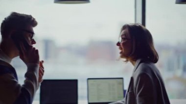 Ofisteki adam cep telefonuyla konuşuyor panoramik salonu kapatıyor. Çok mutlu erkek bayan meslektaşlar beş verdiği için heyecanlı hissediyorlar. Neşeli iş ekibi harika haberler veriyor. Şirket kazananları başarılı oluyor.