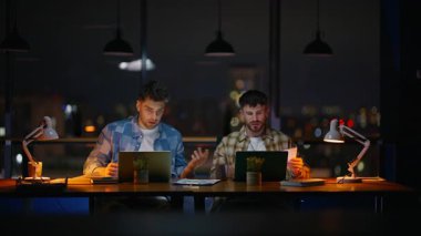 Gece çalışma odasıyla iletişim kuran iki iş arkadaşı yakın çekim yapıyor. Panoramik Ofis 'te evrakları inceleyen bir adam iş arkadaşından bahsediyor. Ciddi takım arkadaşları karanlık iç mekanda son teslim tarihini konuşuyorlar. 