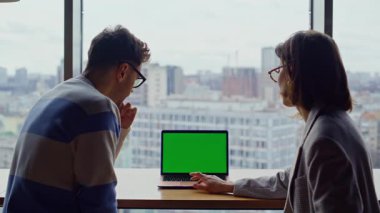 Yöneticiler yeşil ekran dizüstü bilgisayarı hakkında konuşuyorlar. Şehir merkezinde oturuyorlar. Şirket perspektiflerini inceleyen iki iş arkadaşı alet doğrultuyor. İş kadını proje sonuçlarını erkek astına gösteriyor