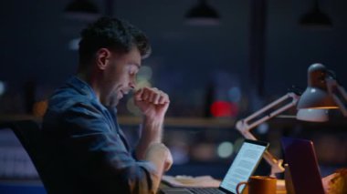 Geç saatlere kadar çalışıp esnemiş bilgisayarları kapalı mekanda esnetiyor. Yorgun iş arkadaşı editörü, klavye yazarken yalan söylüyor. İki meslektaş birlikte çalışıyor ve son teslim tarihini karanlık ofiste yapıyorlar. Fazla mesai konsepti