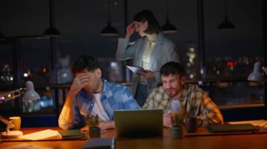 Sinirli acemiler, karanlık ofiste bilgisayar ekranına bakarlar ve fazla mesai problemleri yaşarlar. Gergin iş arkadaşları finansal kayıplara tepki veriyor duygusal olarak bilgisayarlarını kapatıyorlar. Şirket takımı iş başarısızlığını hayal kırıklığına uğrattı