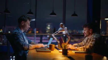 Fazla mesai çalışanları karanlık kabine kapanışında heyecanlı hissediyorlar. İki ofis arkadaşı iş yerinde dizüstü bilgisayarlarıyla beş kişi oturuyormuş. Proje sonuçlarıyla sevinen bilgisayarları daktilo eden mutlu bağımsızlar