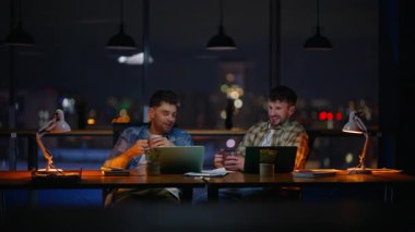 Rahatlamış adamlar ofiste çay yudumluyorlar. İki strateji uzmanı, içki içerek gece çalışma sahasında dostane atmosferin tadını çıkarıyorlar. Olumlu tasasız denetçiler süre bitiminde mola veriyorlar