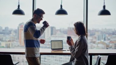 Şehrin arka planında konuşan gülümseyen bir çift. Kasvetli panoramik vitrinlerde içki içen rahat meslektaşlar. Genç ekip işten sonra iletişim kuruyor. İki iş arkadaşı çıkıyor. 