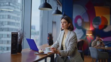 Şehir Kafesi 'nde laptopta çalışan kendine güvenen bir iş kadını. Güzel, zarif bir kadın kapuçino içiyor kafeterya masasında bilgisayarla oturuyor. E- posta iletisi klavyesi yazan ciddi yönetici serbest yazar