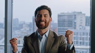 Heyecanlı kazanan büyük ofis portresindeki iş başarısını kutluyor. Aşırı mutlu duygusal iş adamı modern şirket binasında tek başına zafer kazanıyor. Neşeli menajer kendine güvenini dile getiriyor 