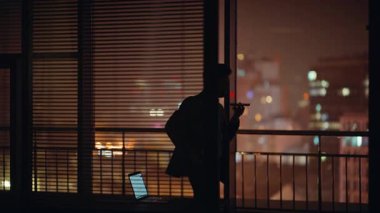 Endişeli avukat silueti akşam panoramik kabinede cep telefonuyla konuşuyor. Endişeli iş adamı evde gergin bir cep telefonu görüşmesi yapıyor. Gergin CEO duygusal olarak konuşuyor.