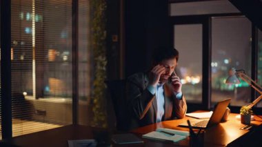 Sinirli patron karanlık ofiste şık bir takım elbise giyip cep telefonuyla konuşuyor. Stresli, zarif bir avukat, akıllı telefon konuşmasını gergin bir şekilde yapıyor. Duygusal lider yüksek tonda konuşuyor.