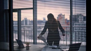 Stresli iş kadını silueti el hareketleriyle şehir merkezindeki dolaba bakıyor. Öfkeli meslektaşım parmaklarını dizüstü bilgisayara doğrultup bağırıyor. İçeride iş sorunları olan iki yönetici.