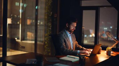 Sessiz stüdyo içinde gece vardiyası sırasında profesyonel organizasyon fikirleri. Masaüstünde yazı yazan belirlenmiş yönetici inceleme notları. Hırslı lider yaklaşan hedefler için veri arıyor. 