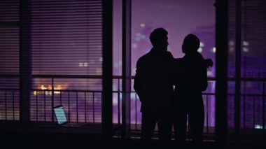 Neon şehir manzarasına bakan koyu renk siluetler. Bilinmeyen romantik çift, şehvetli sohbetleri kucaklıyor. Zarif bir adam karısını işaret ederek flört ediyor. Mimari izleyen iki kişi.