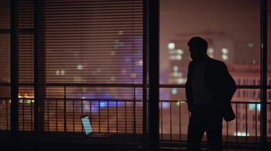 Endişeli adam silueti düşünme sorunu panoramik ofis dikiz görünümlü gece şehri tasarlama. Takım elbiseli şirket yöneticisi pencereye bakıyor. İş yerinde gelecek hayalleri kuran profesyonel bir iş. 