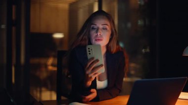 Gece işkadını ofis çalışma alanındaki cep telefonundan mesaj okuyor. Rahat bir kadın cep telefonuyla sosyal medyaya e-posta atıyor. Çok çalışan yönetici tek başına akıllı telefonla rahatlıyor. 